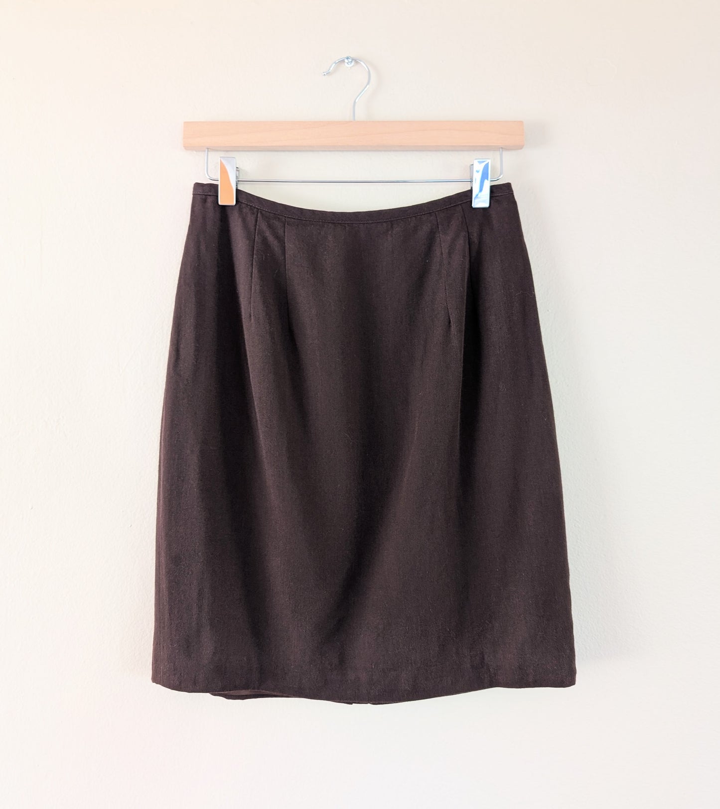 Brown skirt on a hanger against a white background