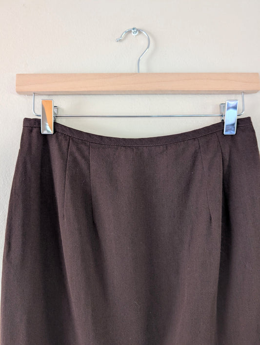 Brown skirt on a hanger against a plain background