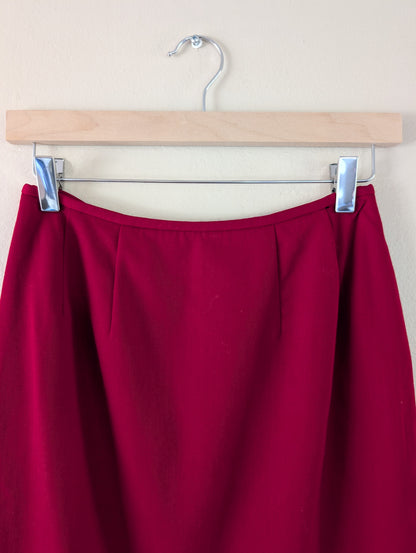 red wool pencil skirt on hanger against white background
