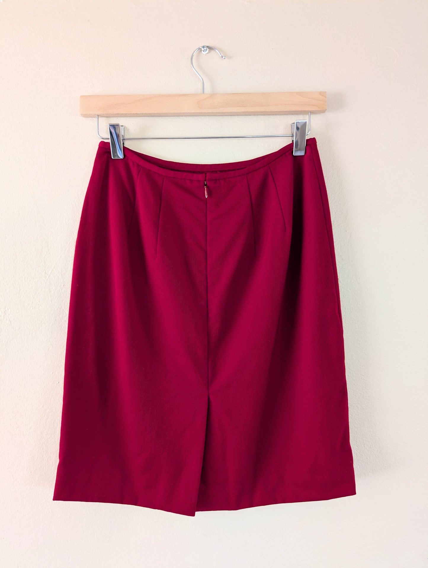 red wool pencil skirt on hanger against white background