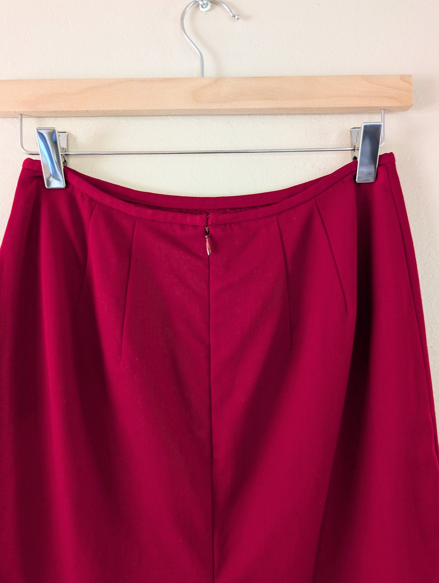 red wool pencil skirt on hanger against white background