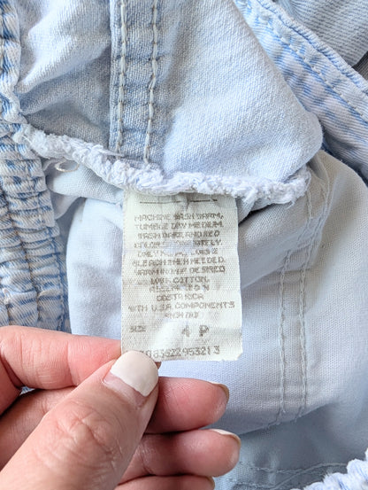 Close-up of a clothing tag on a piece of light blue fabric.